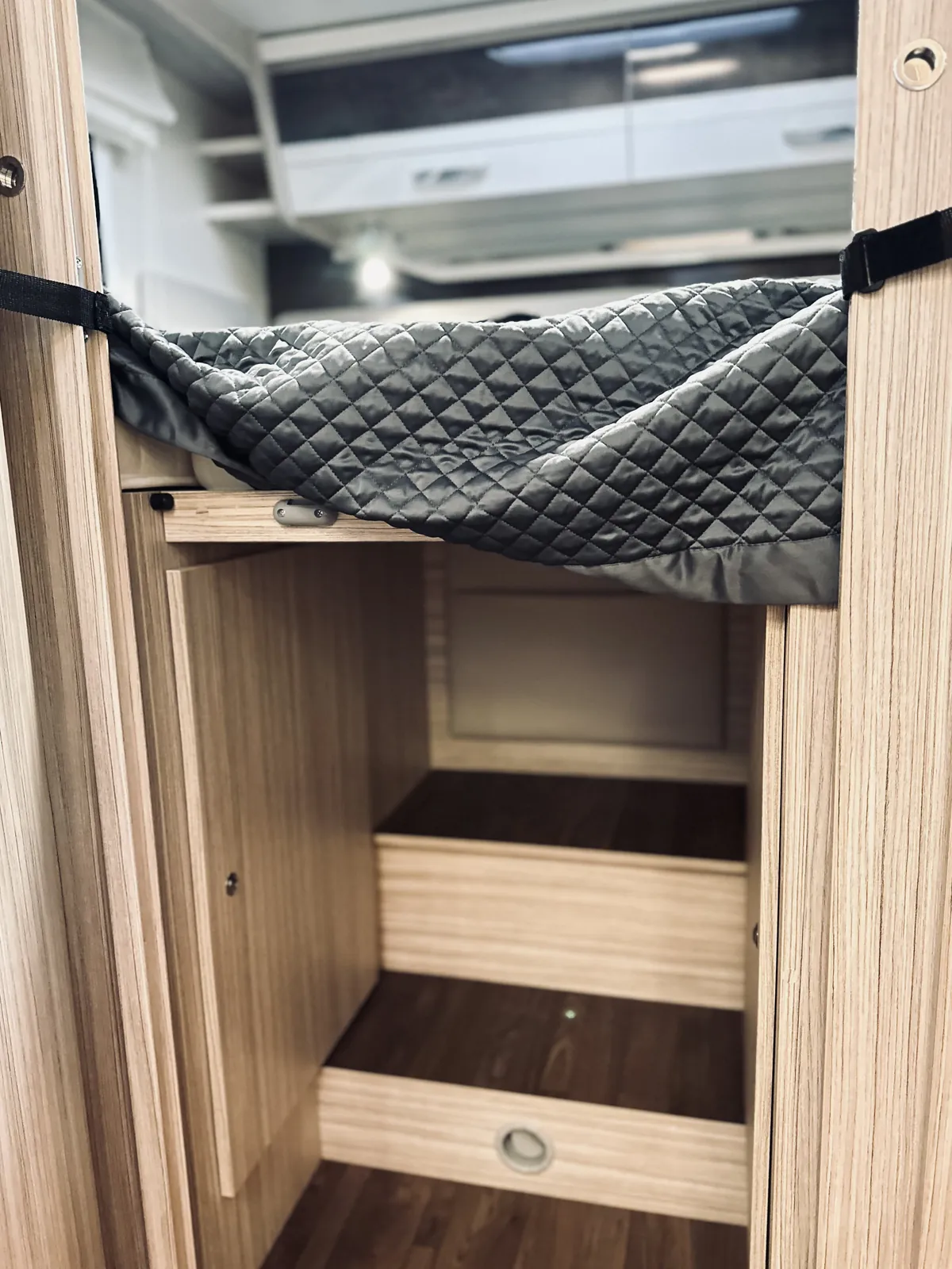 Kleiderschrank mit Regalböden und angehobener Matratze