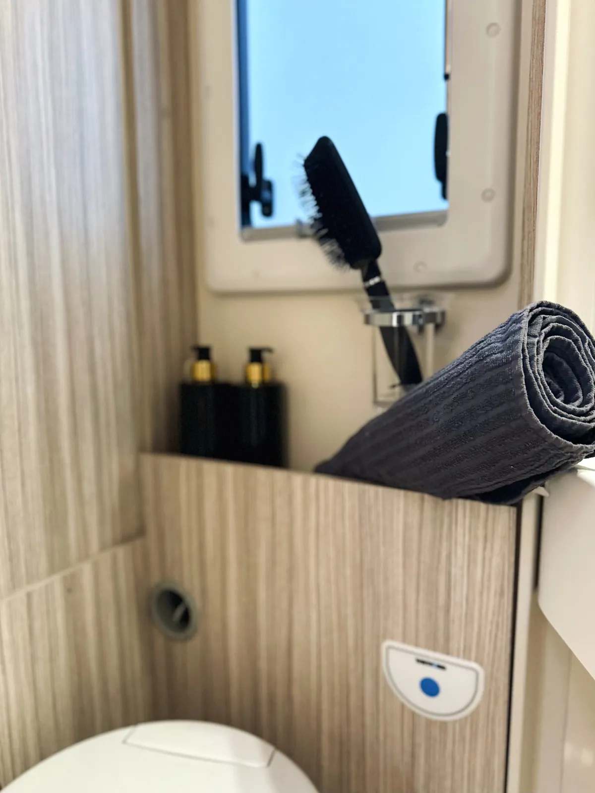WC mit Ablage, Fenster und Handtuch